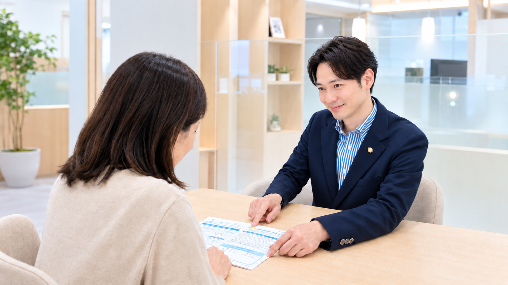 明るく爽やかな表情で女性のお客様に保険をご案内するスタッフ